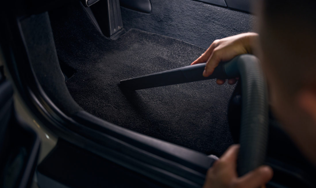 vacuuming floor of car